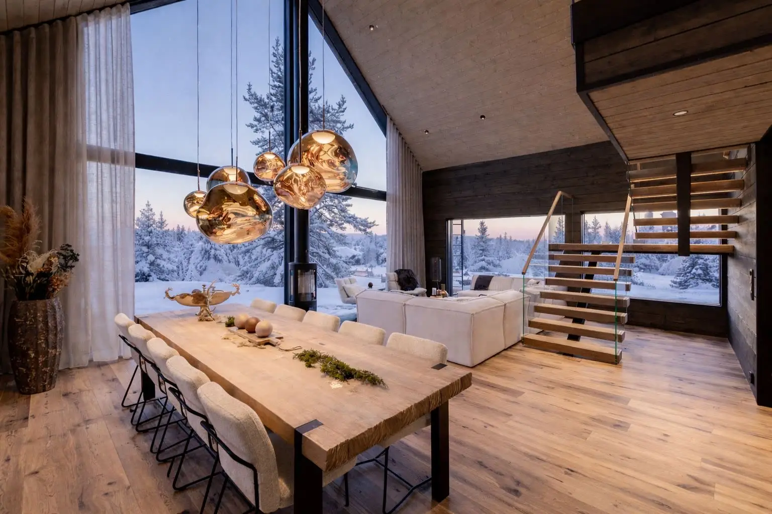 Grand Panoramic dining table under copper pendants with a floor to ceiling window onto snowy forest at dusk