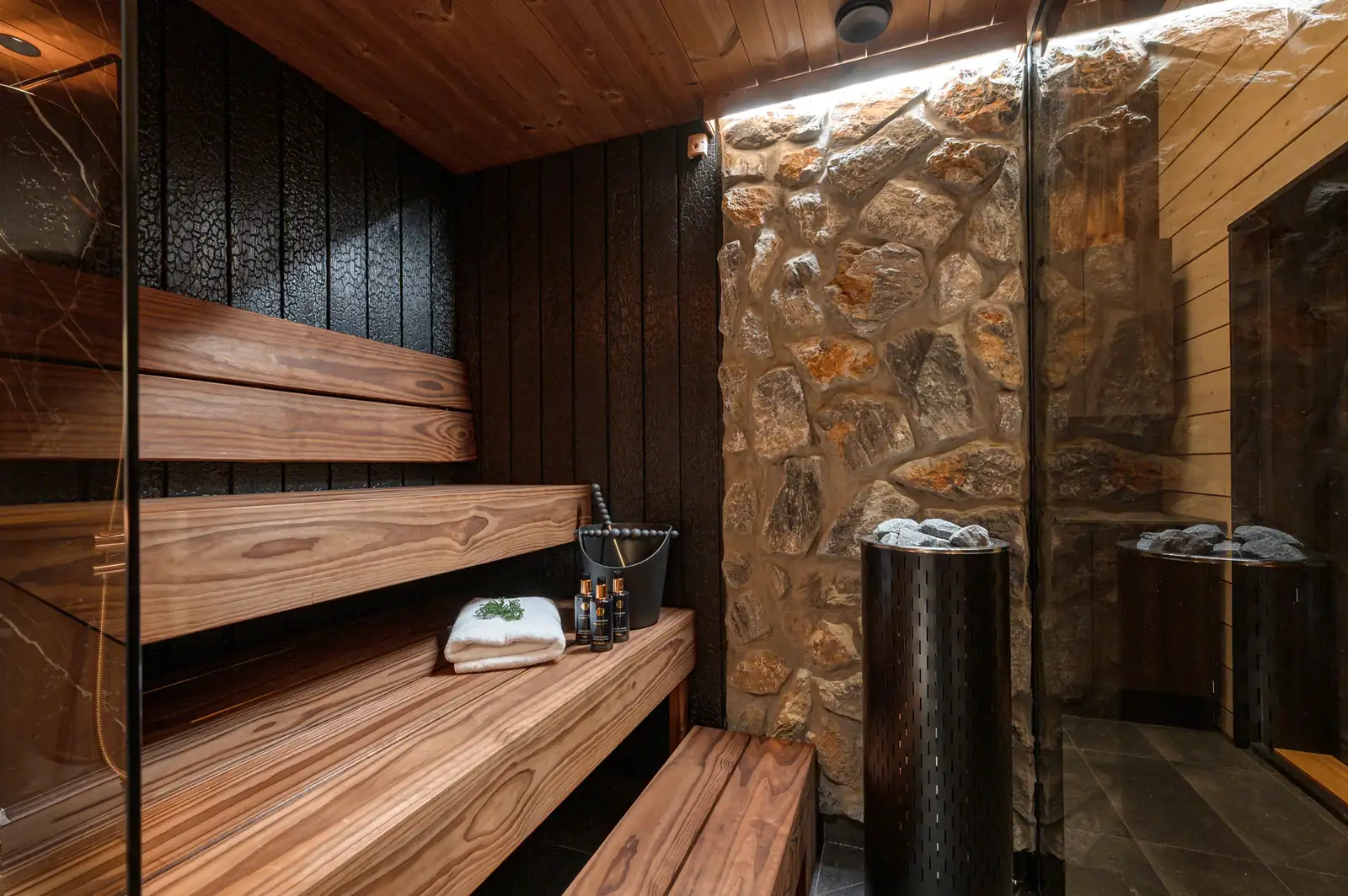 Private Finnish sauna at Aura Arctic Chalets with panoramic glass wall and winter forest view