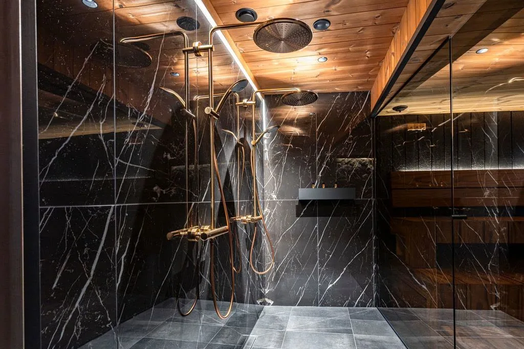 Private spa with black marble walls and brass rain showers