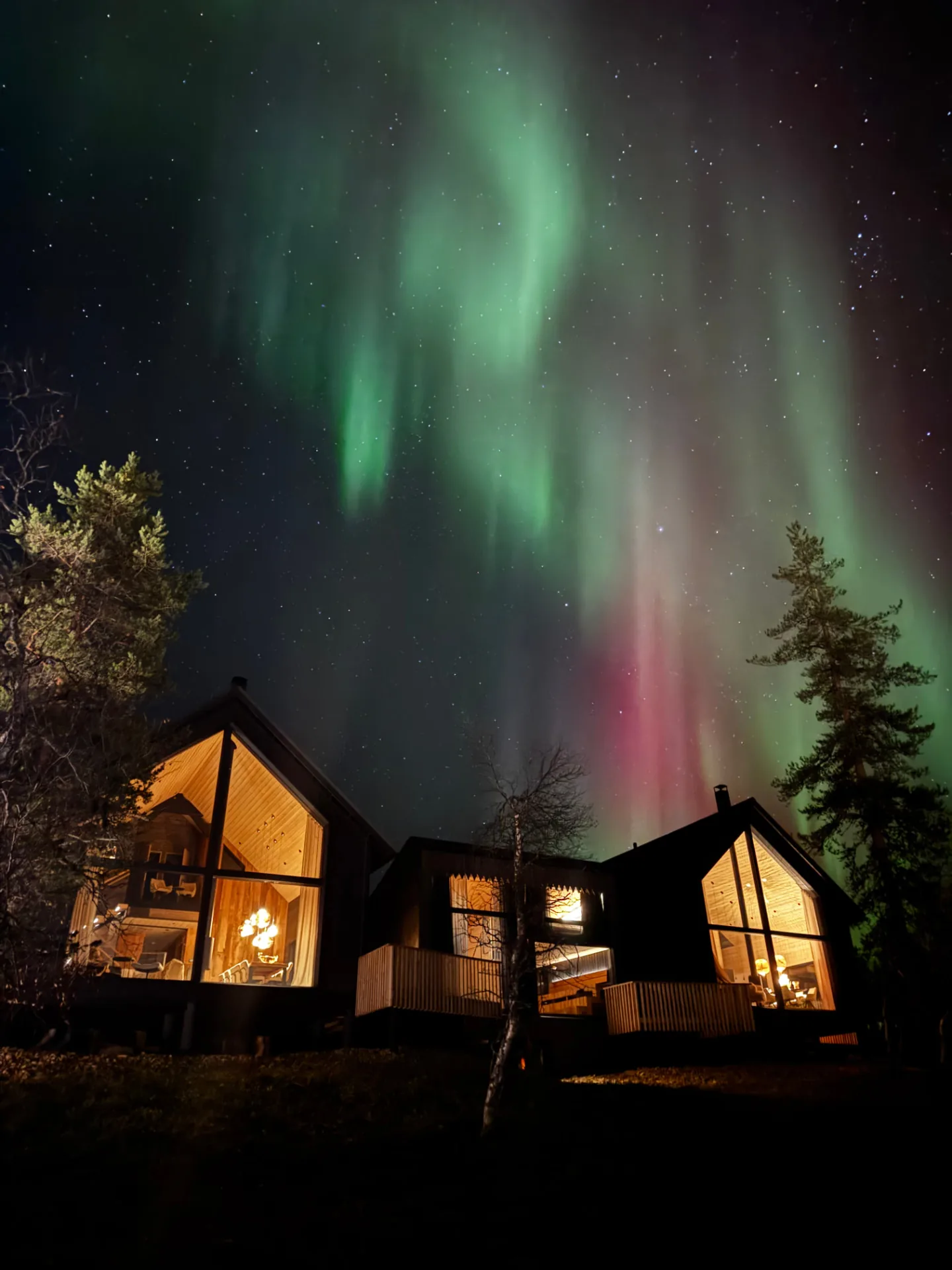 Aura chalet glass fronts and terraces beneath the northern lights